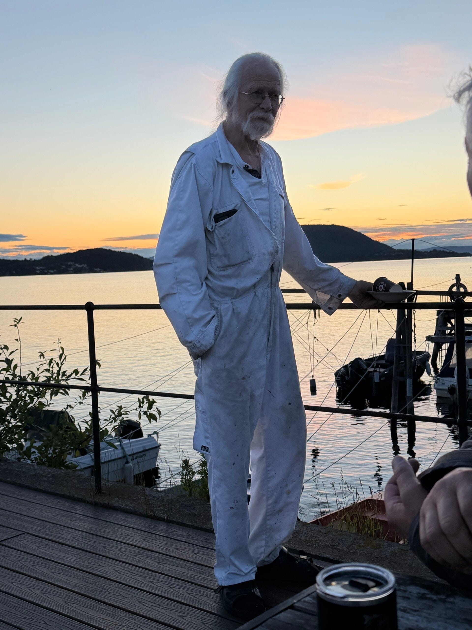 Kunstner Reidar Finsrud på brygga i Drøbak ved solnedgang